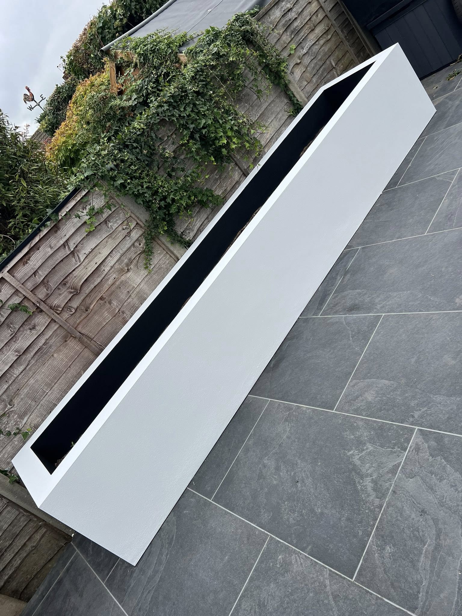 White planter on paved patio